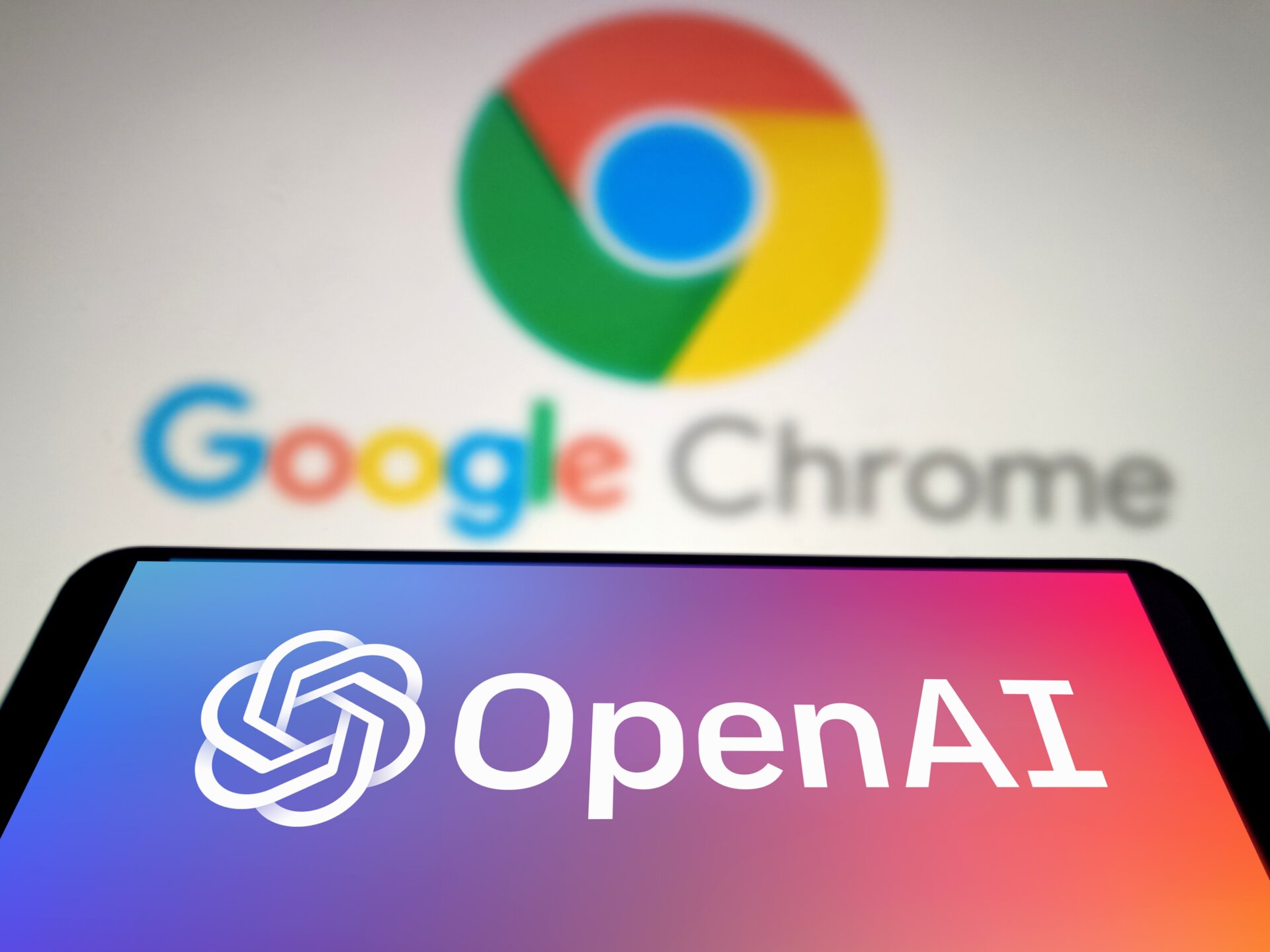 OpenAI logo displayed on a smartphone in front of Google Chrome logo