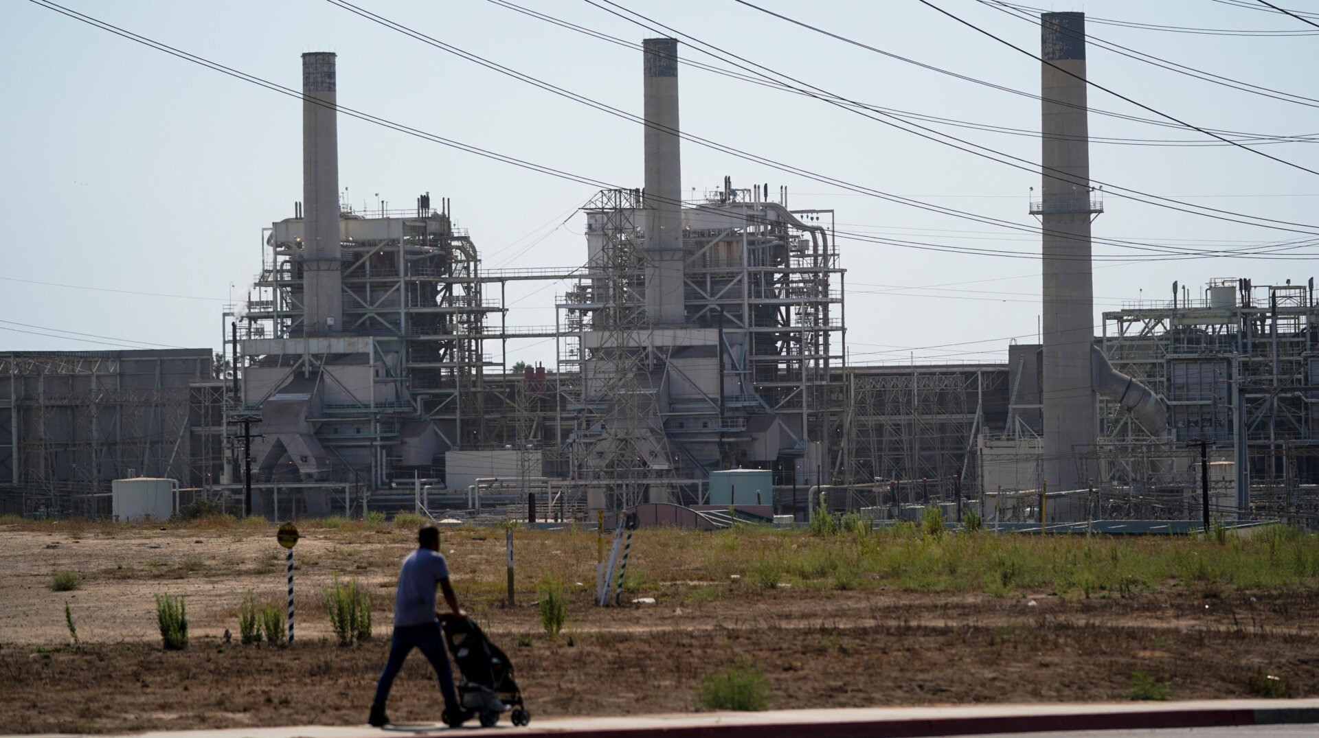 A man pushes a stroller near the AES power plant in Redondo Beach, California