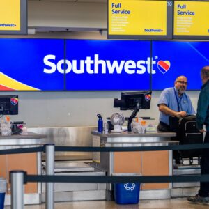 A Southwest Airlines employee assists a passenger during their check-in at the Austin-Bergstrom International Airport on April 18, 2023 in Austin, Texas. Southwest Airlines suffered a brief disruption in operations earlier this morning after a computer firewall issue forced the company to delay many of its flights. (Photo by Brandon Bell/Getty Images)