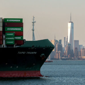 A container ship is seen leaving the Port Jersey Container Terminal with the Manhattan skyline in the background
