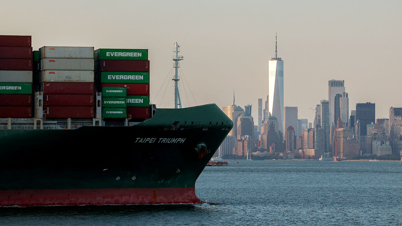 A container ship is seen leaving the Port Jersey Container Terminal with the Manhattan skyline in the background