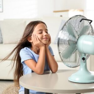 Gadis kecil menikmati kipas angin yang keren