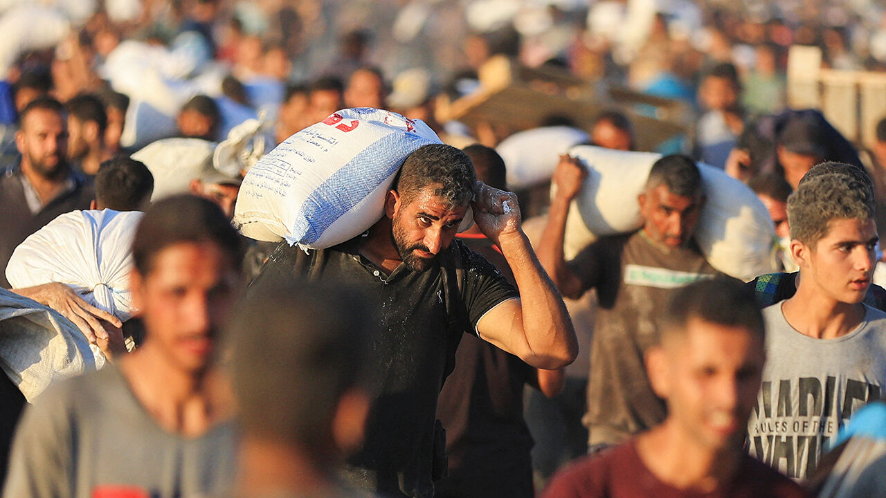 Palestinians carry aid supplies that entered Gaza through Israe
