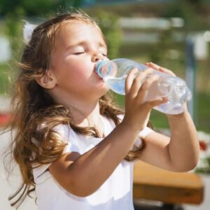 Gadis Kecil Minum Air Dari Botol Plastik